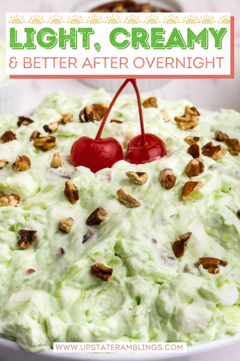 A bowl of light green creamy pistachio fluff salad topped with two cherries and chopped nuts, with text overlay promoting it as light, creamy, and better after overnight.