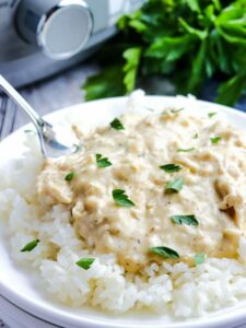 closeup of creamy slow cooker chicken on rice.