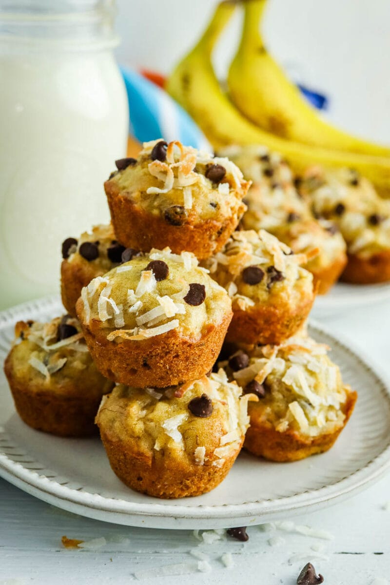 Closeup of a stack of banana coconut muffins on a plate with milk.