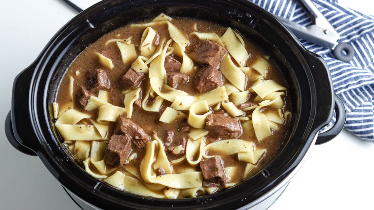 top view of beef and noodles in a crock pot.