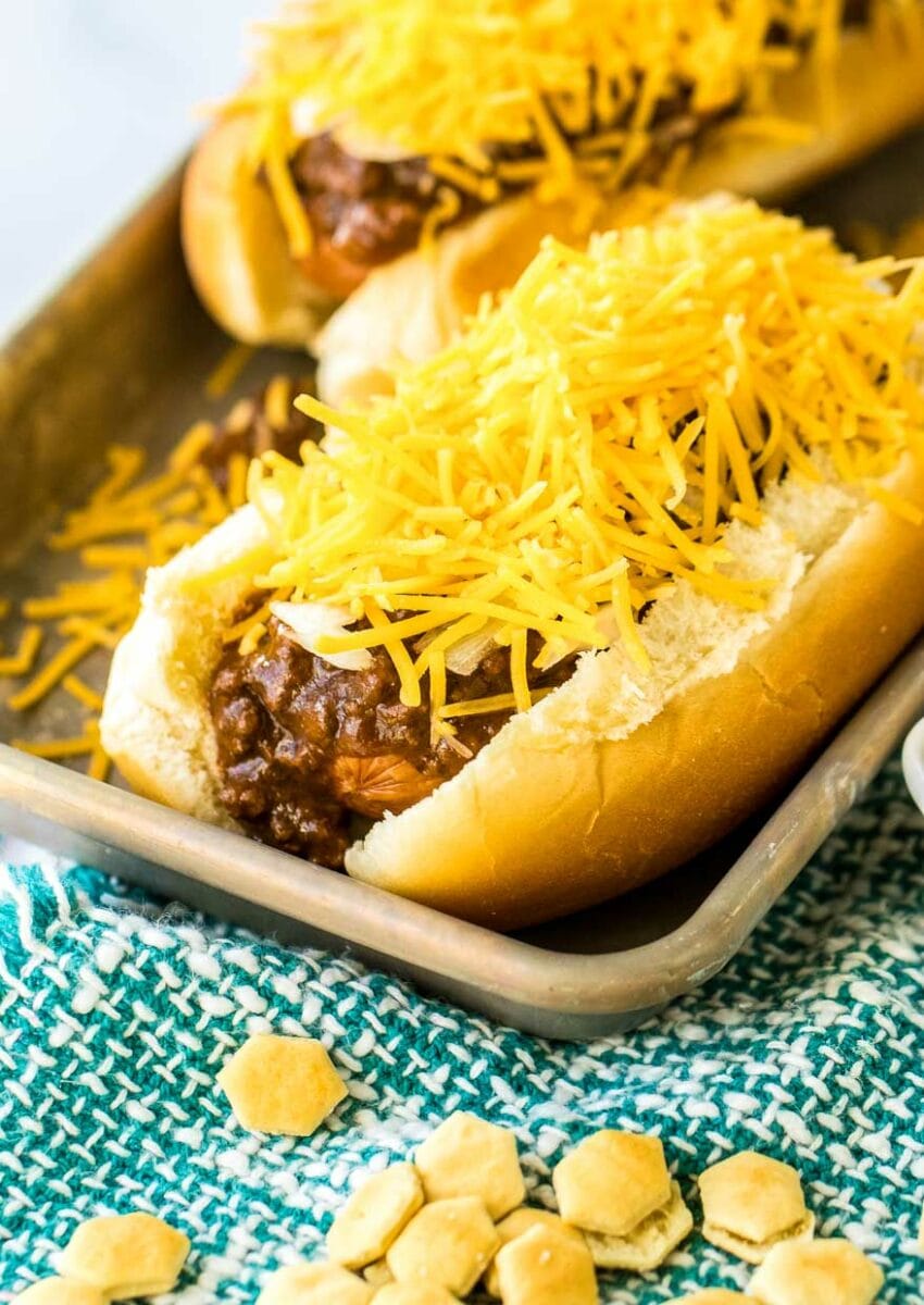 topping a hot dog with Chili and cheese.