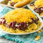 plate of Cincinnati chili topped with cheese, beans and onions.