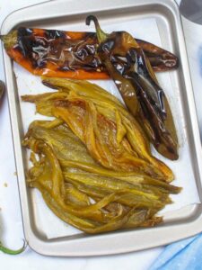 roasted hatch chiles on a metal tray.