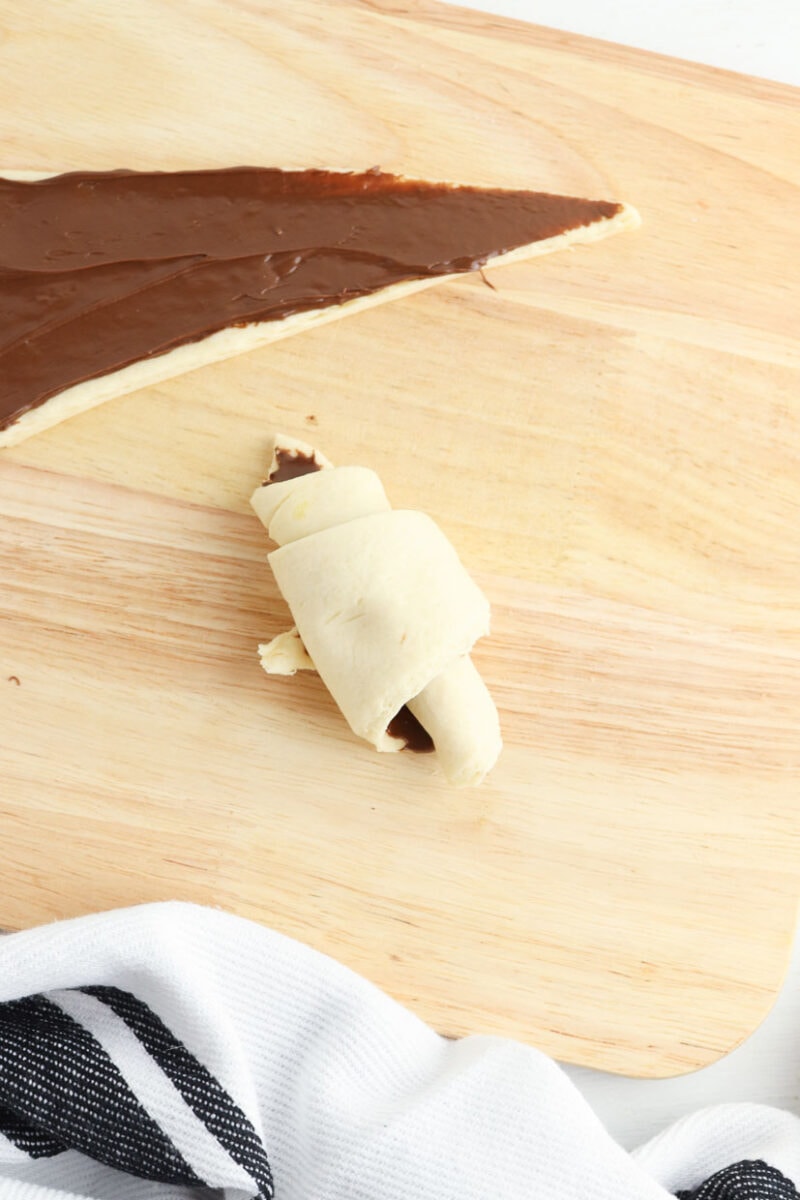Rolling up the nutella crescent rolls with nutella.
