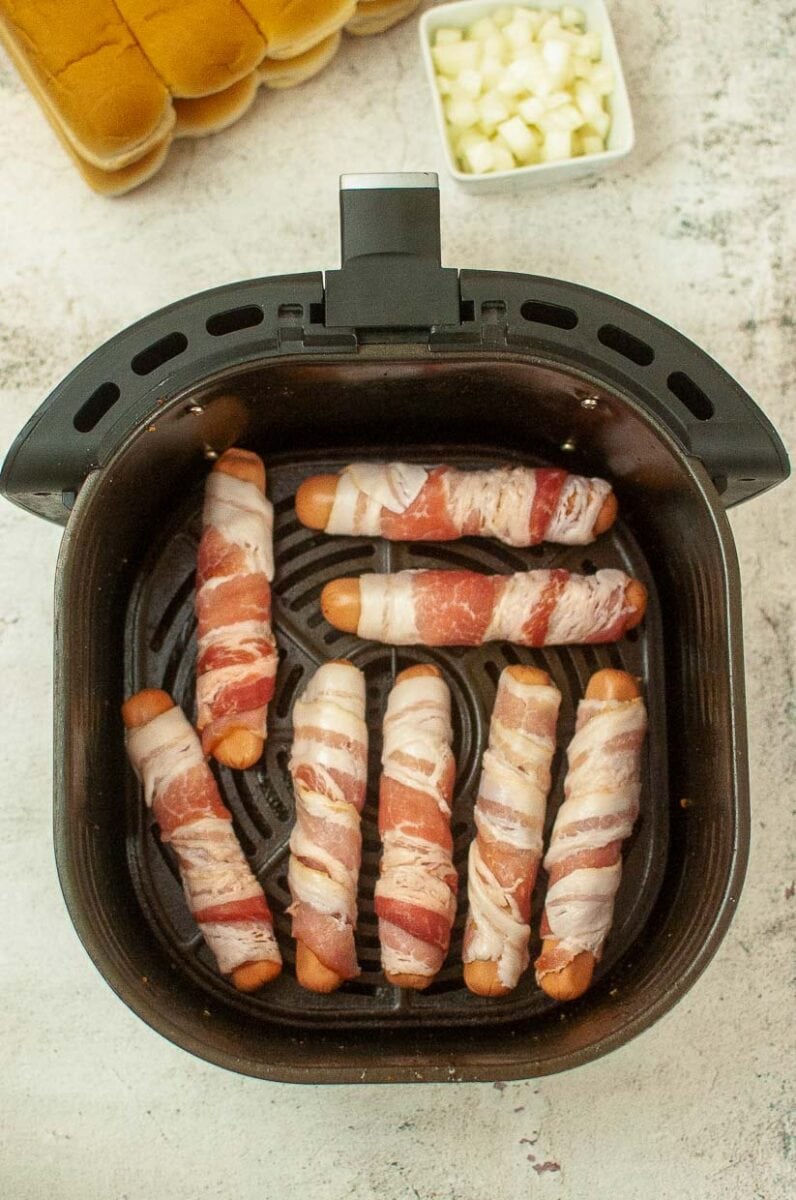 Bacon wrapped hot dogs before air frying.