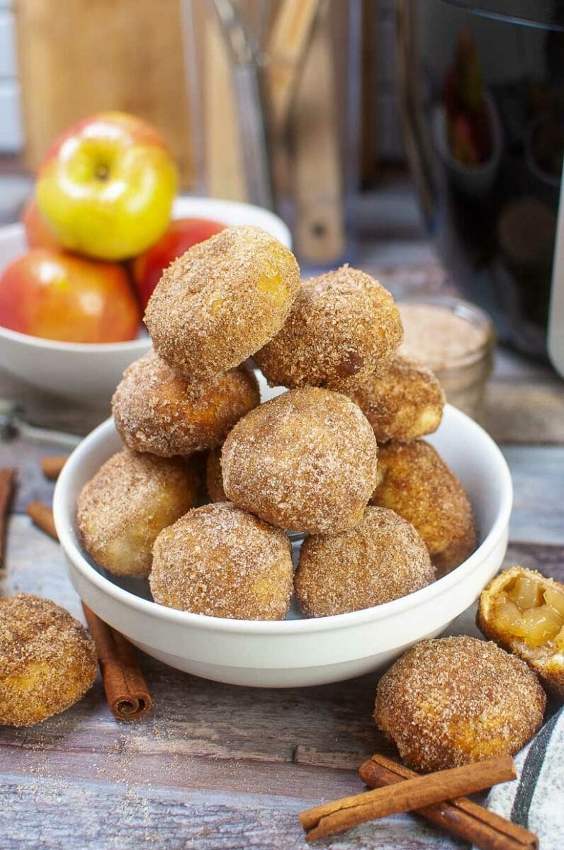Stack of air fryer apple pie bites in a white bowl.