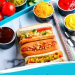 Pinterest pin hot dog bar showing hot dogs in buns with toppings.