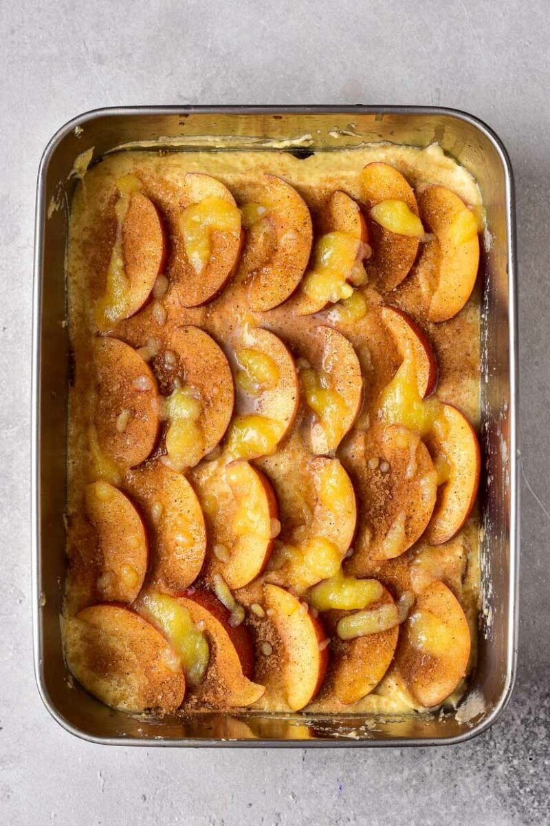 Add more peaches to the cake pan.