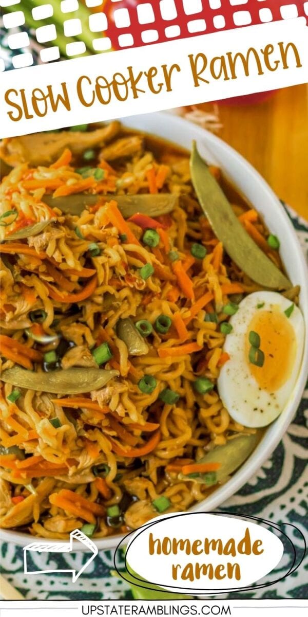 A bowl of homemade crock pot ramen topped with green onions, snap peas, shredded carrots, and half a boiled egg.