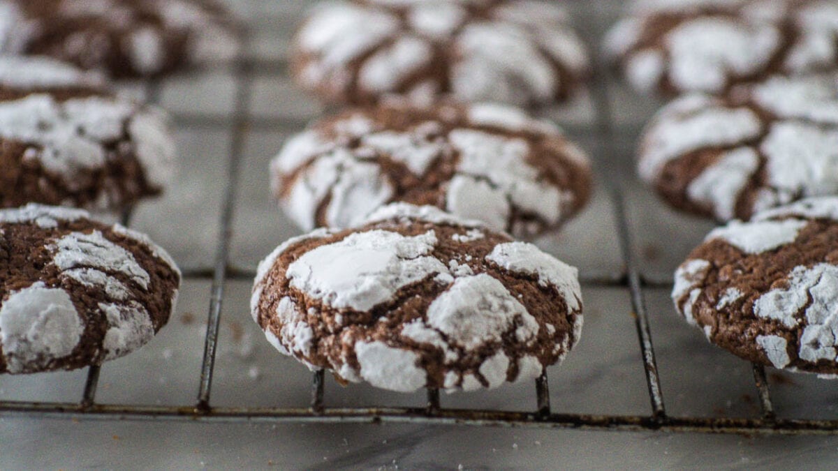 Chocolate crinkle cookies on a baking rack cooling.
