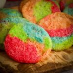 Jello cookies with a tie dye pattern on a cutting board.