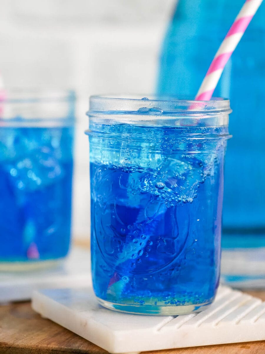 Copycat sonic ocean water in a mason jar glass with a pink straw.
