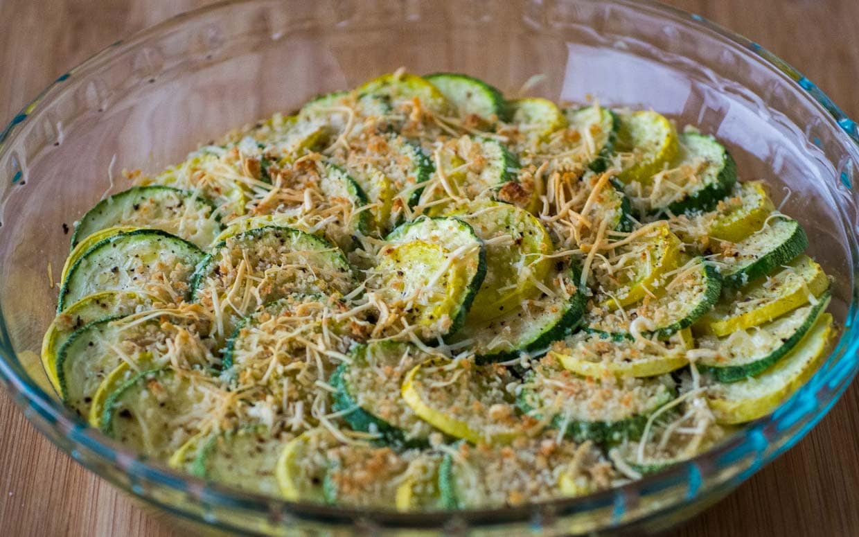 Zucchini and summer squash alternated in a dish topped with breadcrumbs.