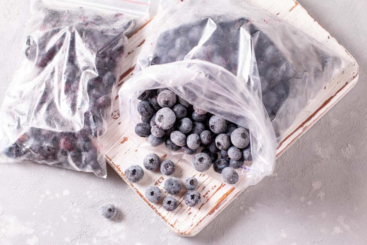 Bag of frozen blueberries on a cutting board.