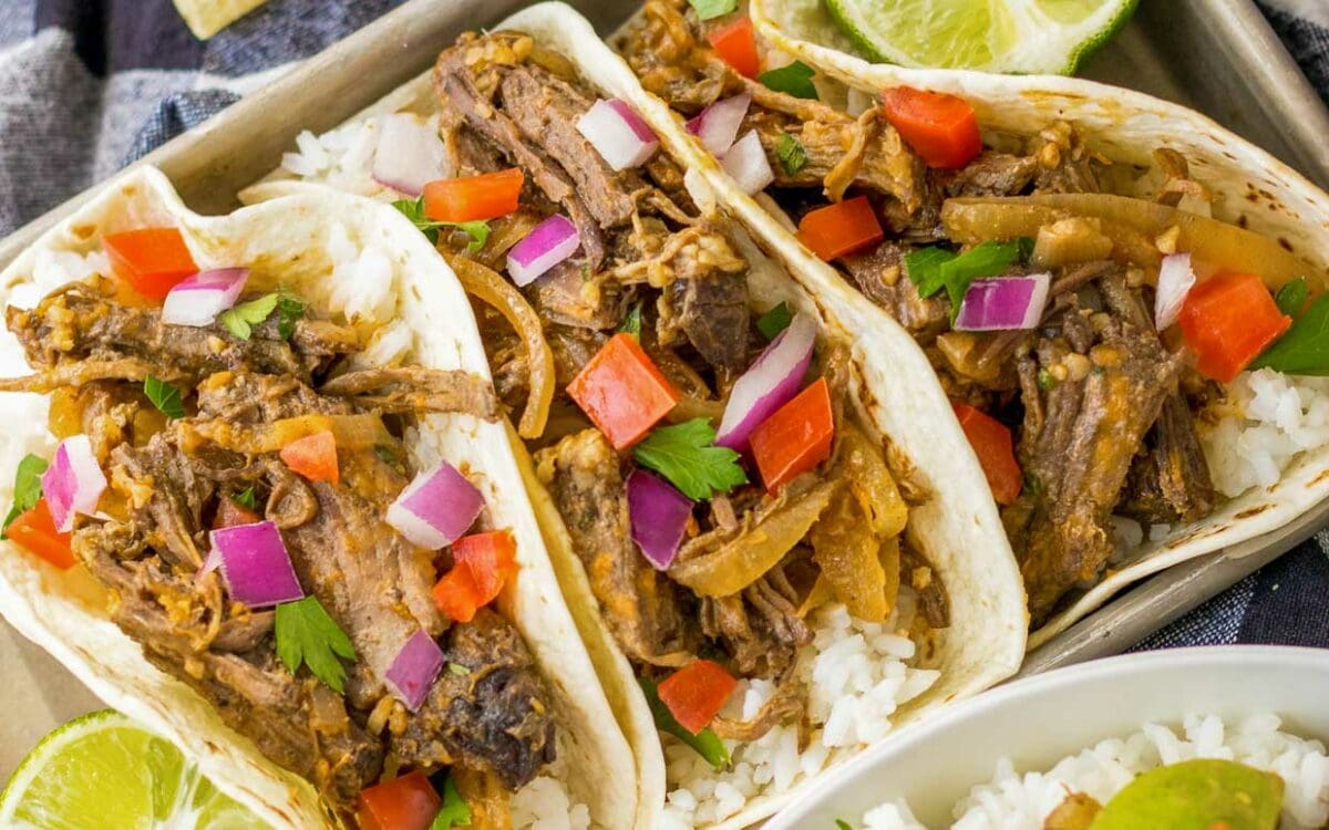 Slow cooker copy cat chipotle barbacoa served as tacos on a tray.