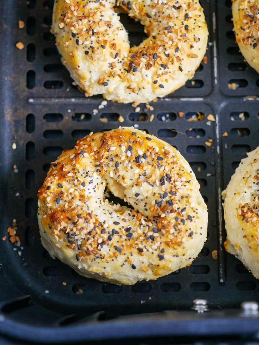 Bagels in the oven with sesame seeds on them.