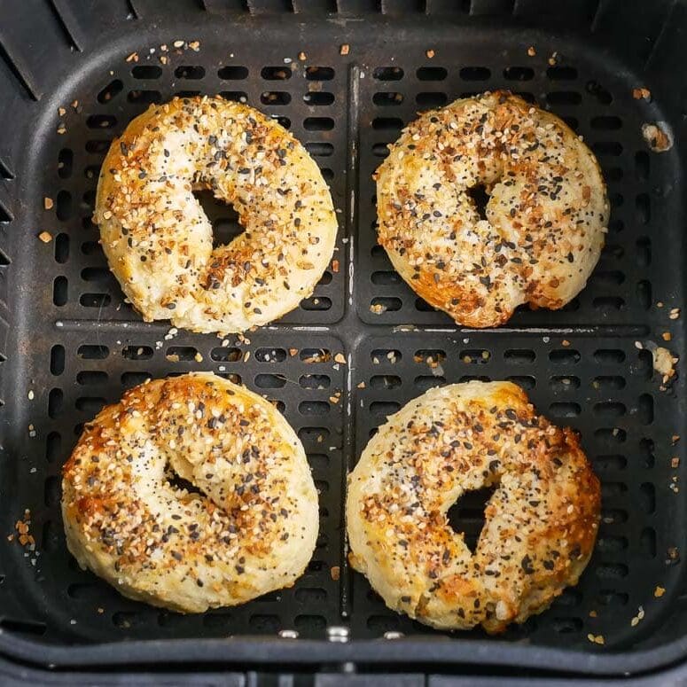Bagels in an air fryer with sesame seeds.