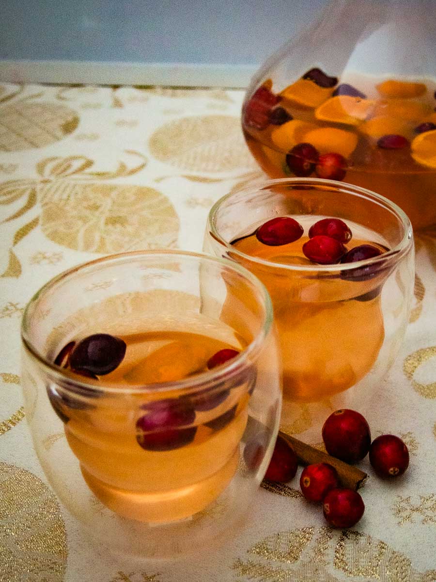Two glasses of cranberry juice with sugared cranberries in them.