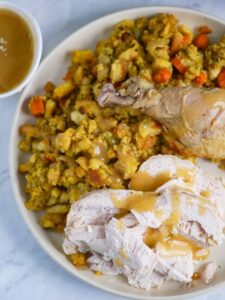 Thanksgiving turkey with gravy and stuffing on a white plate.