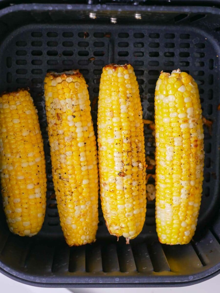Corn in basket of air fryer.