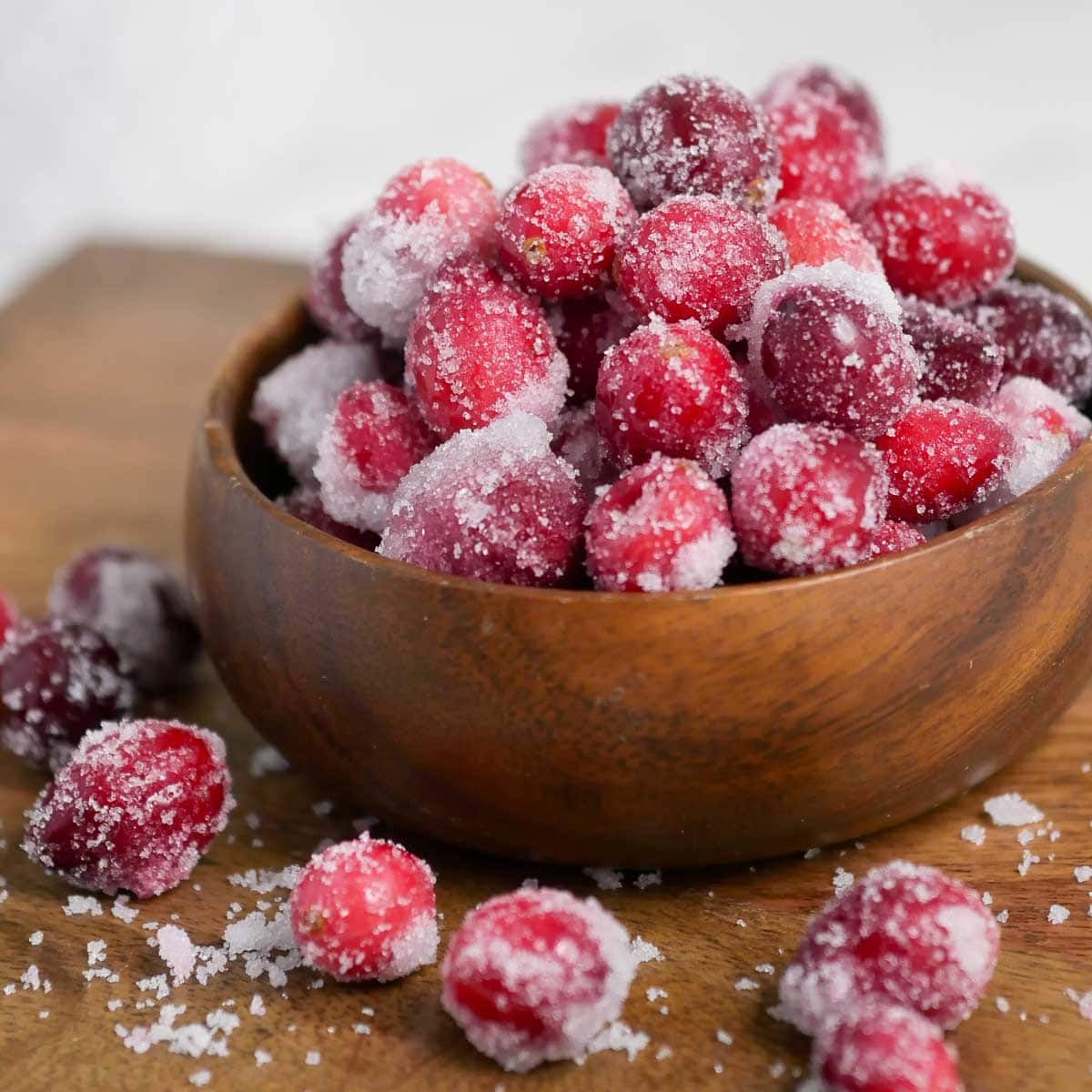 Sugared cranberries in a wooden bowl.