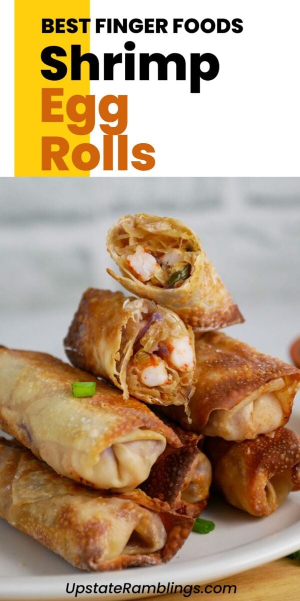 A stack of golden-brown shrimp egg rolls sits on a plate, with one shrimp egg roll cut open to reveal its savory shrimp filling.