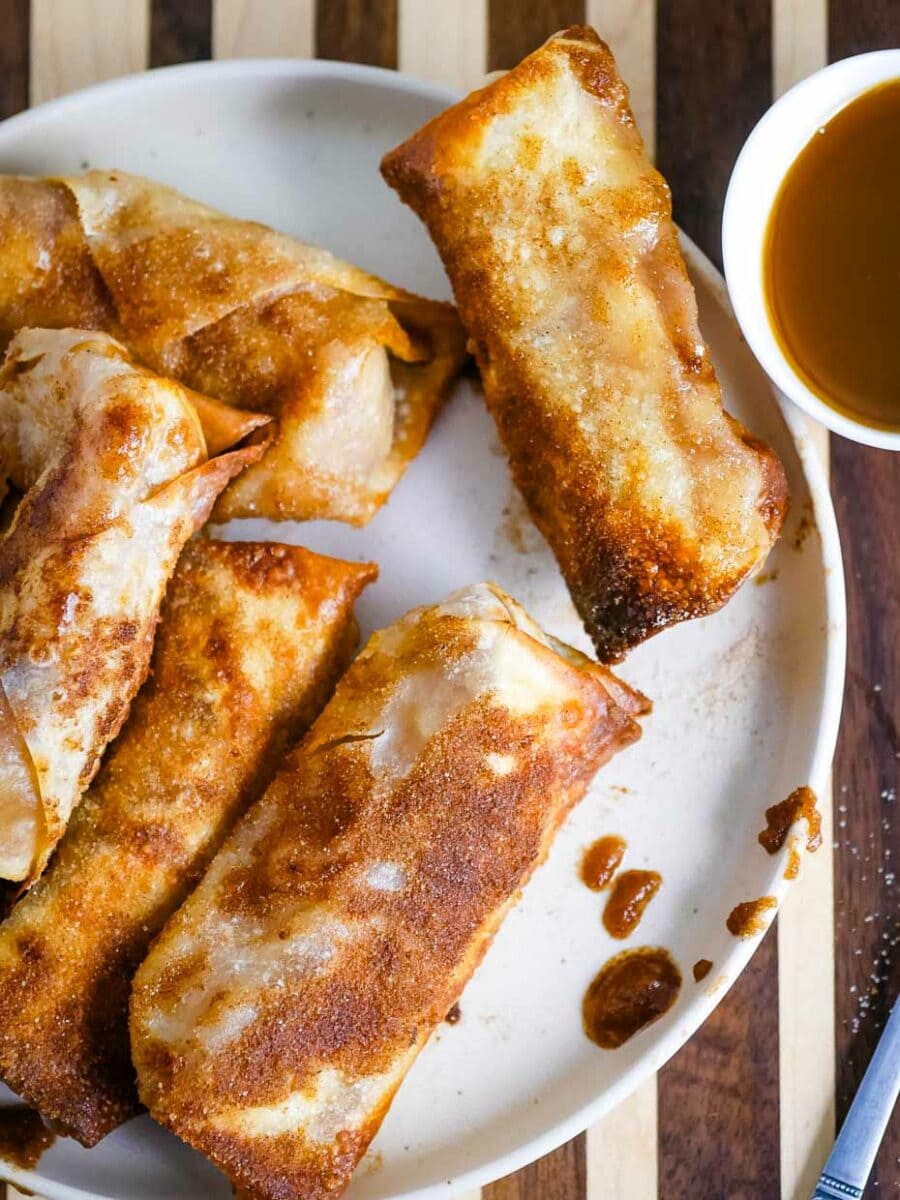 Top view of a plate of apple pie egg rolls.