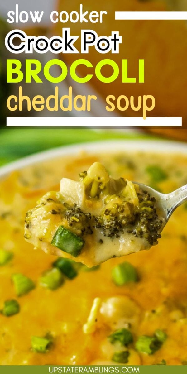 A spoonful of cheddar broccoli soup is held above a bowl, garnished with green onions. Text on image reads: “slow cooker crock pot broccoli cheddar soup.”.