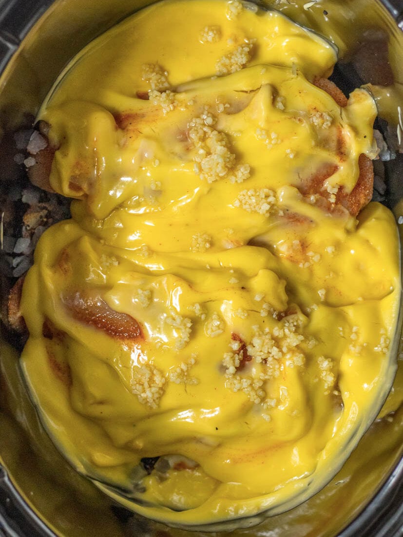 A crock pot filled with a yellow sauce.