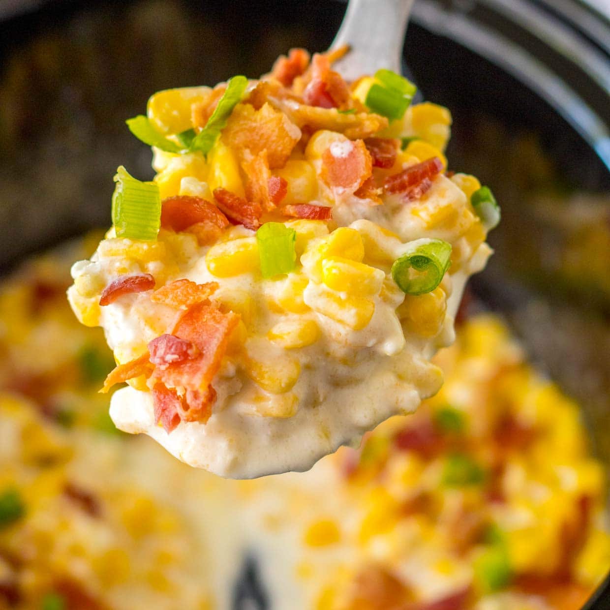 Slow cooker creamed corn on a spoon.