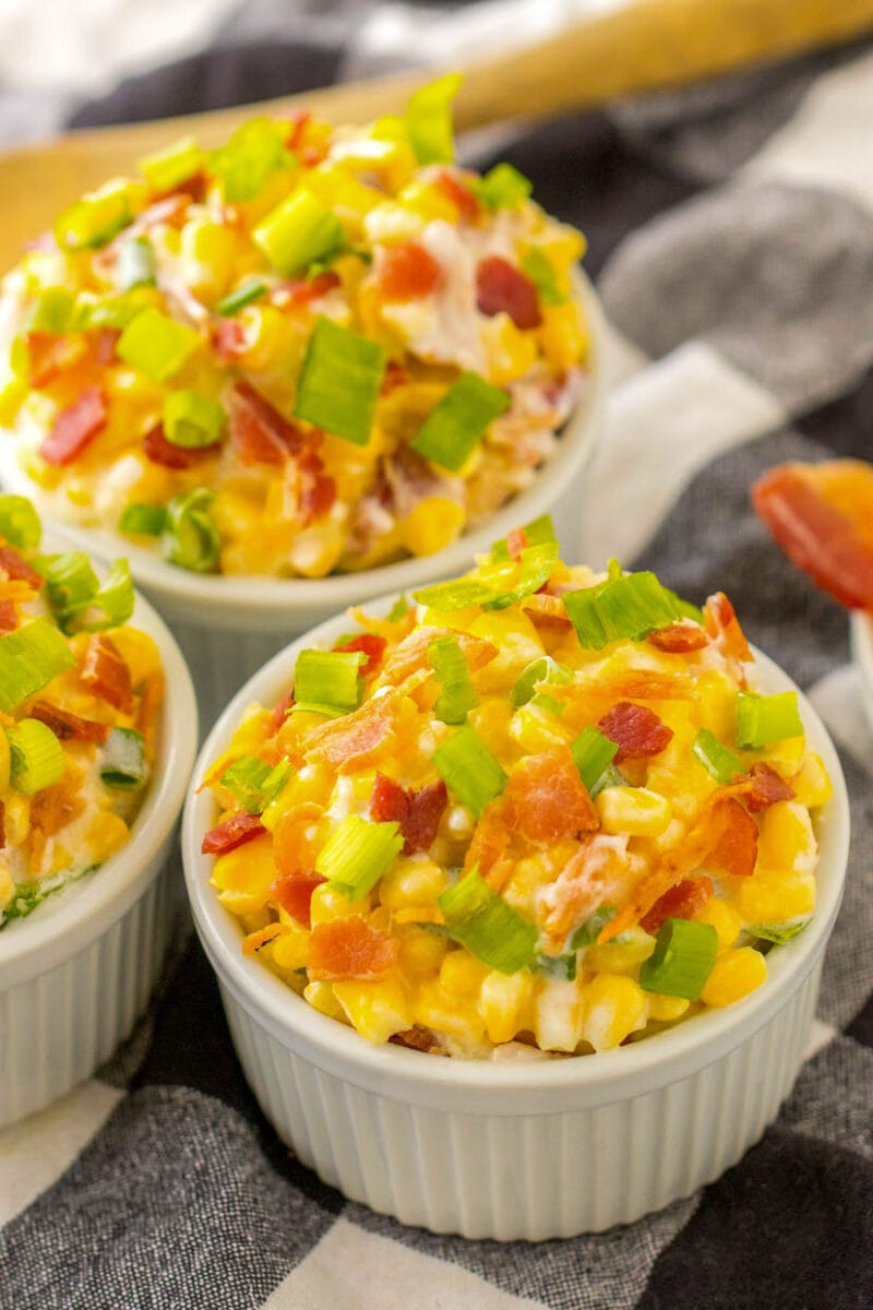 Bowls of creamed corn topped with bacon and green onions.