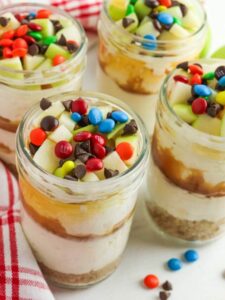 Apple cheesecake in jars with m&ms.