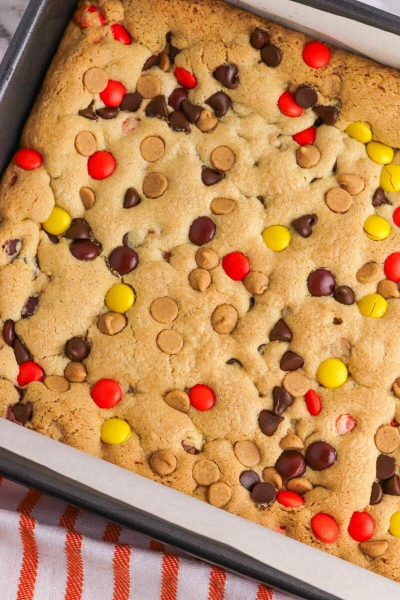 A baking pan filled with cookies and m & m's.
