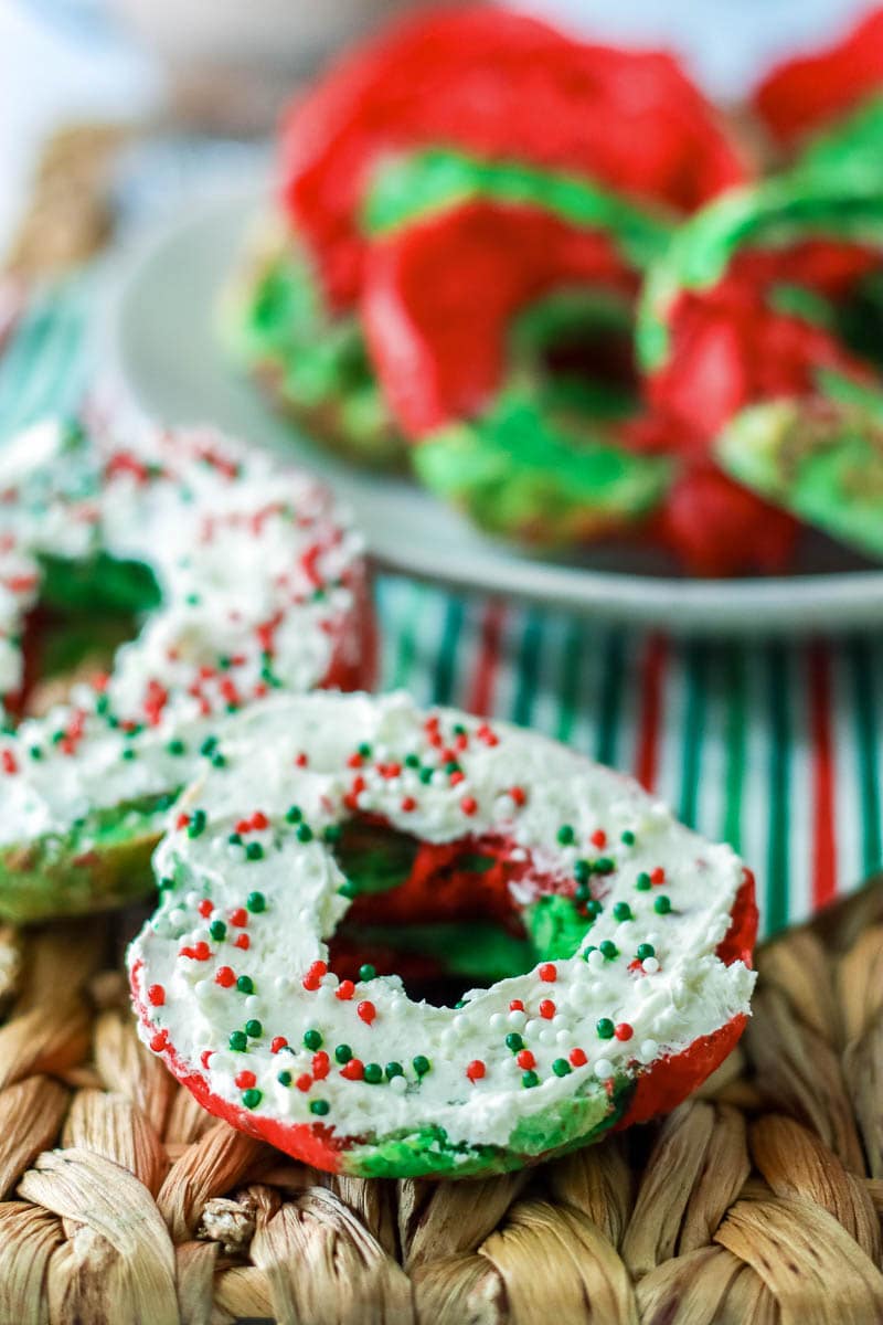 Christmas bagels with icing and sprinkles on a wicker basket.
