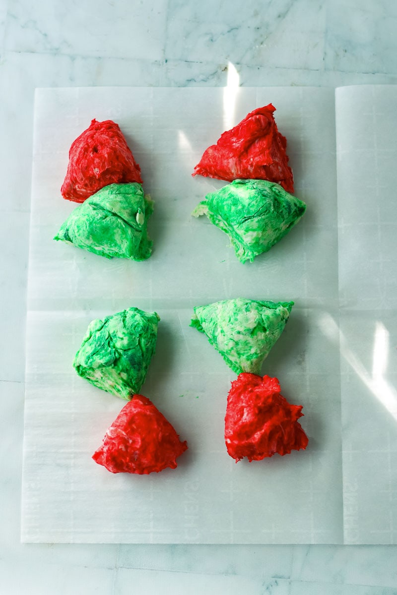 A sheet of green, red, and white icing on a white surface, resembling festive Christmas bagels.