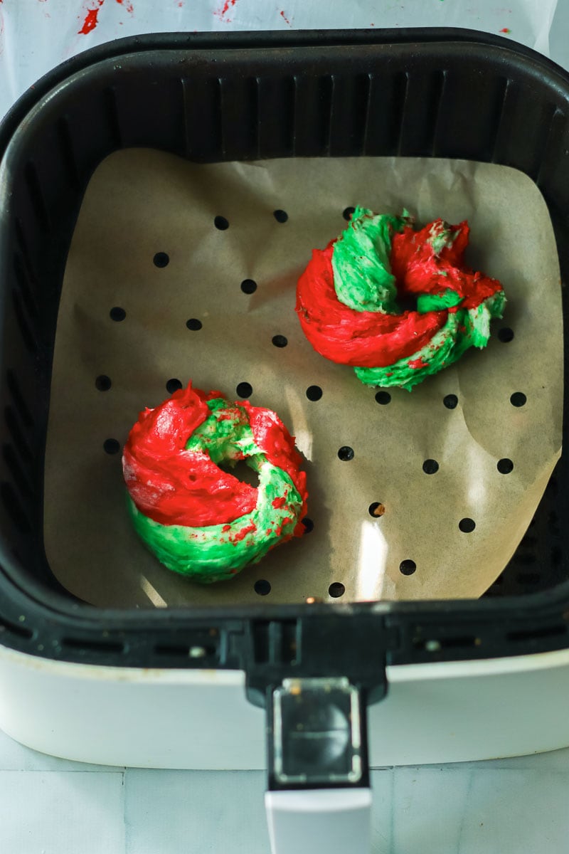 Two Christmas cookies in an air fryer.