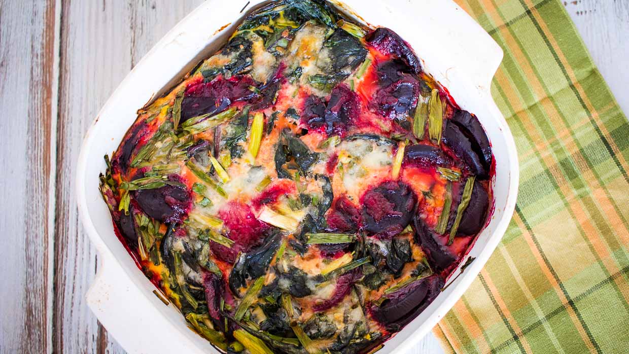 A casserole dish filled with beets and spinach.