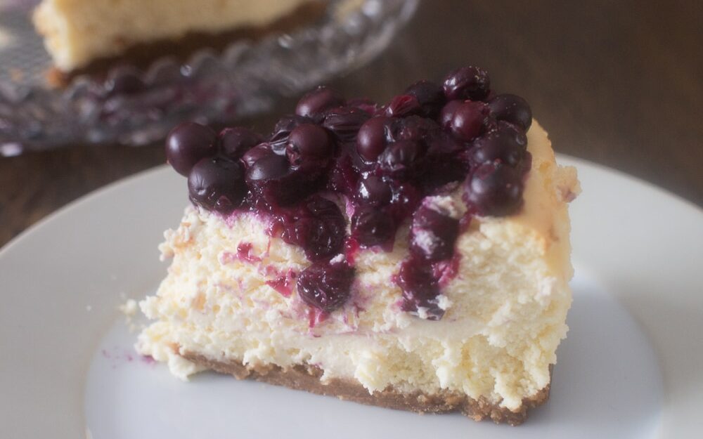 Slice of blueberry cheesecake on a plate.