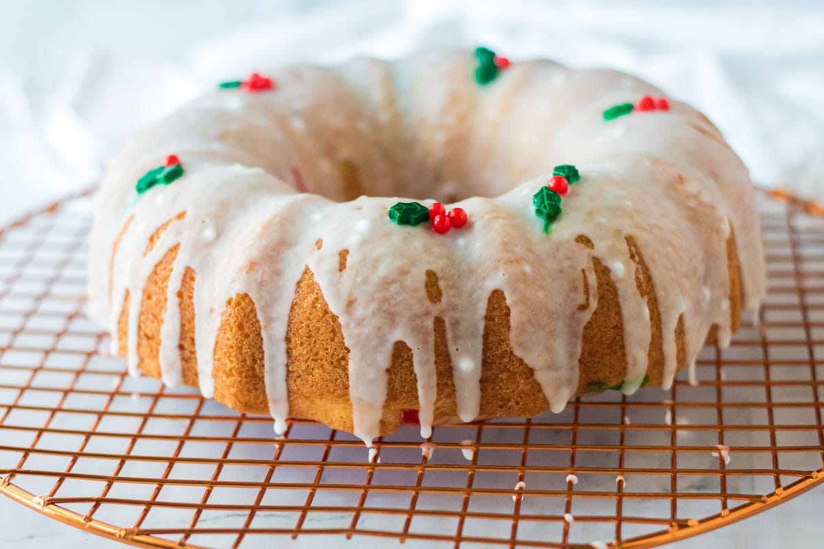 A Christmas bundt cake adorned with icing and holly berries.