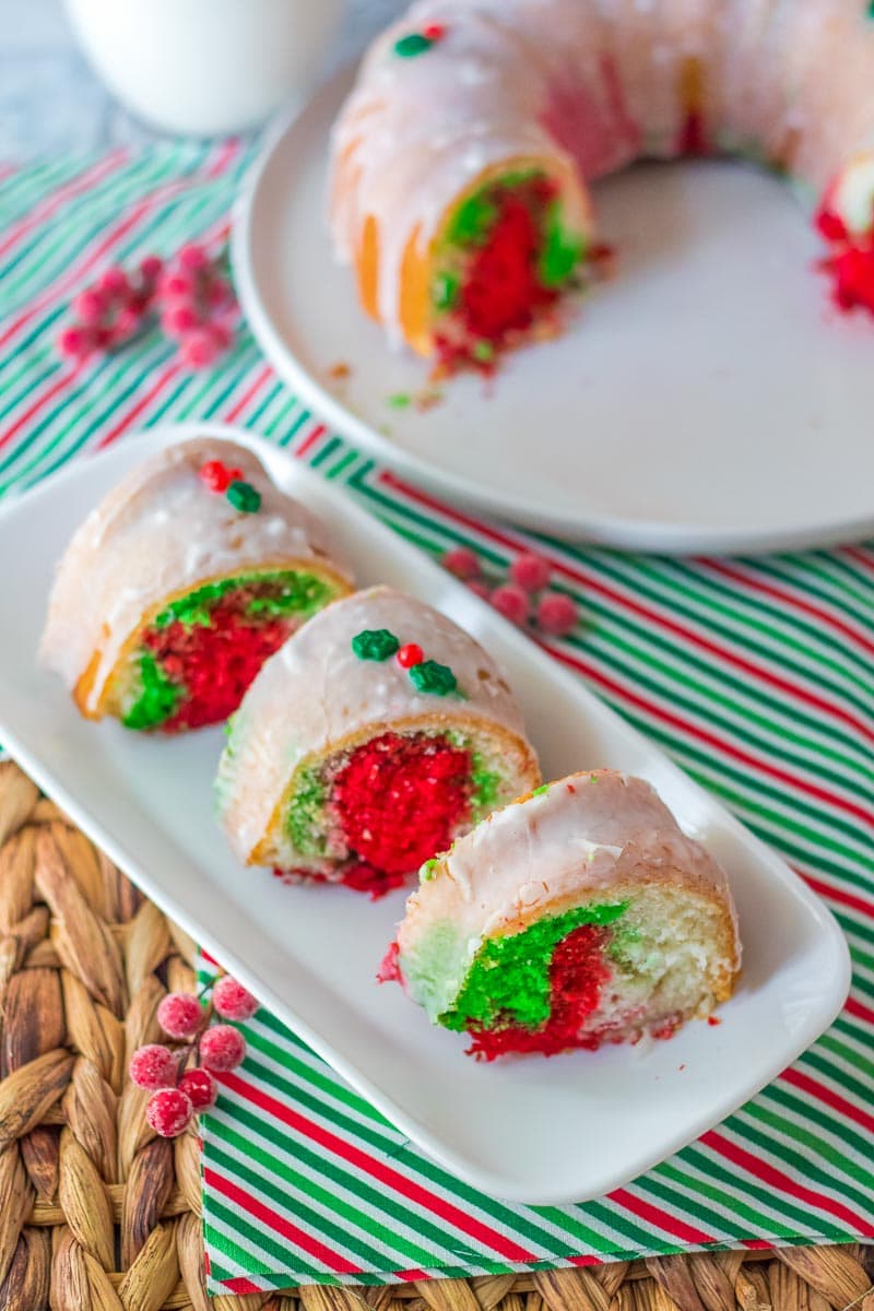 A festive Christmas bundt cake on a plate with green and red sprinkles.