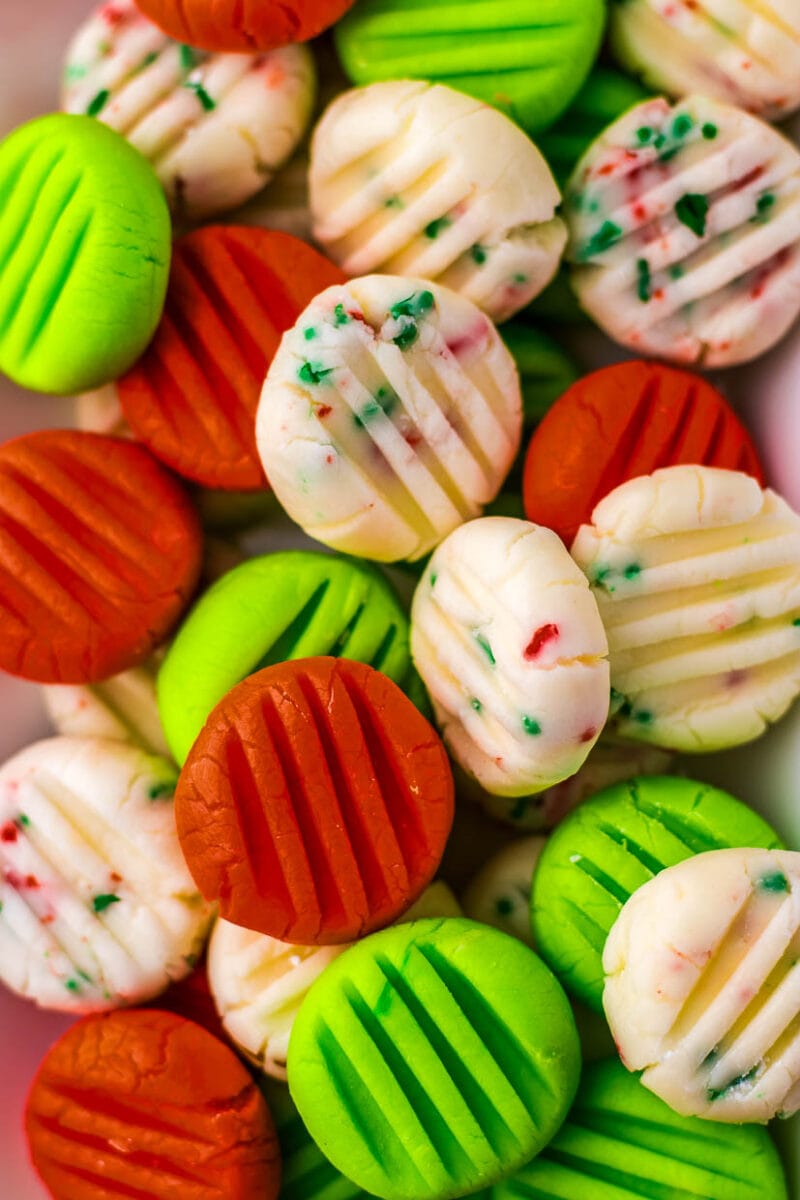 A pile of candy canes with green, red, and white stripes.
