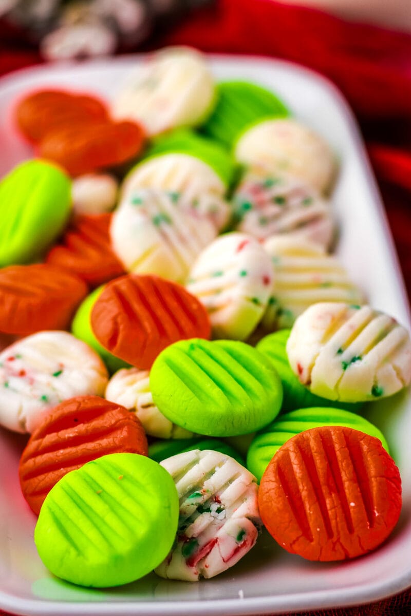 Christmas cookies on a white plate with red and green sprinkles.