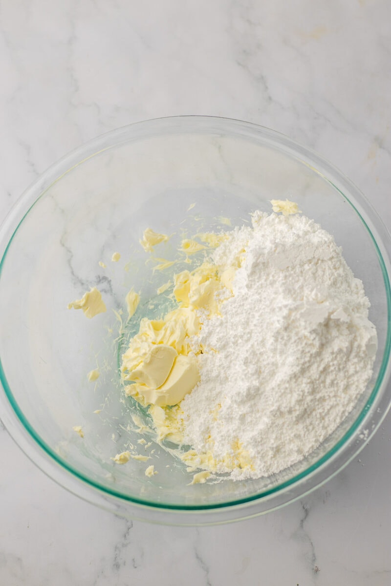 A glass bowl with flour and butter in it.