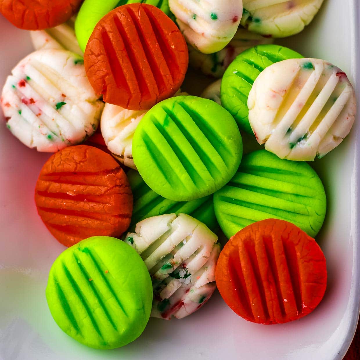 A white plate with green, orange, and red mints.