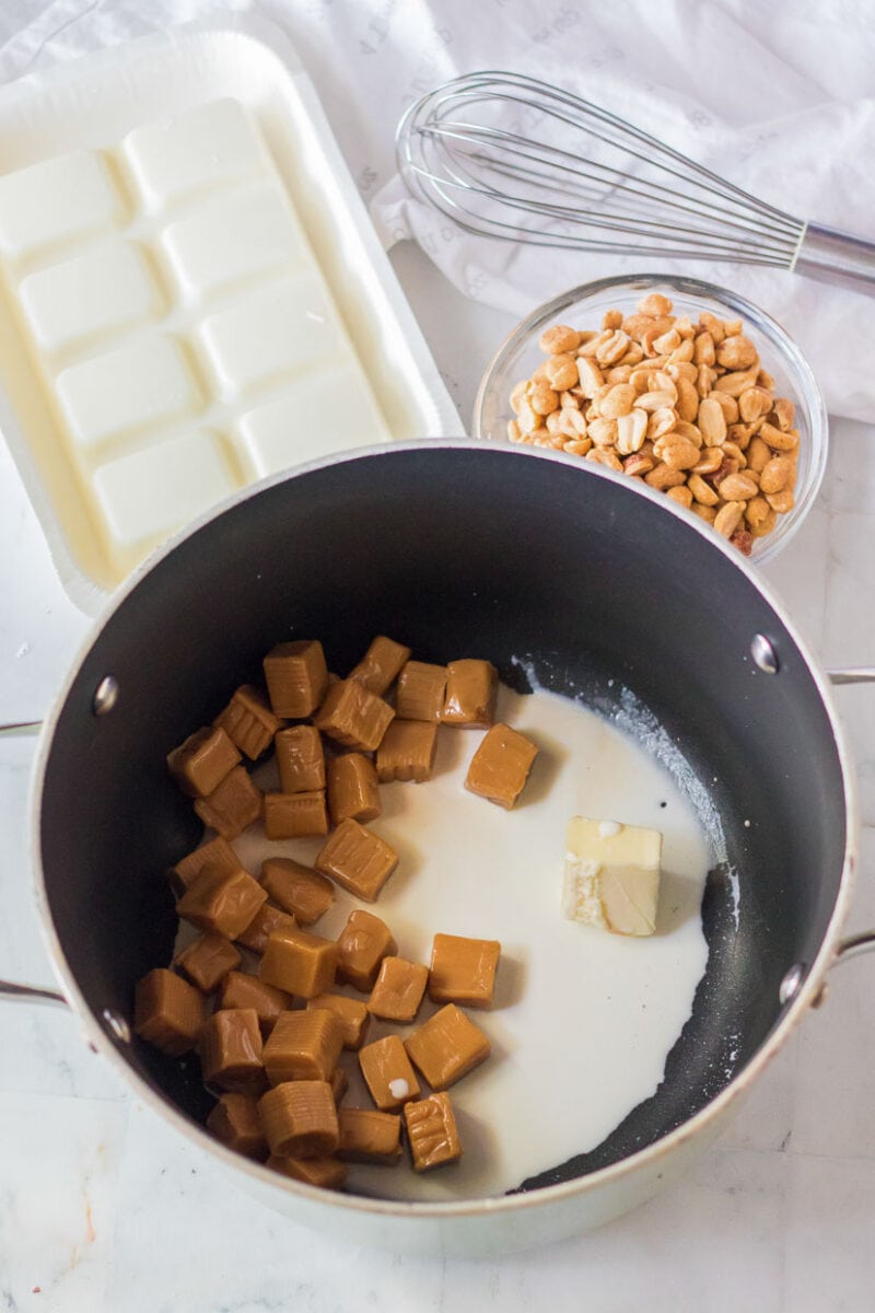 Caramel cubes in a pan on a marble countertop.