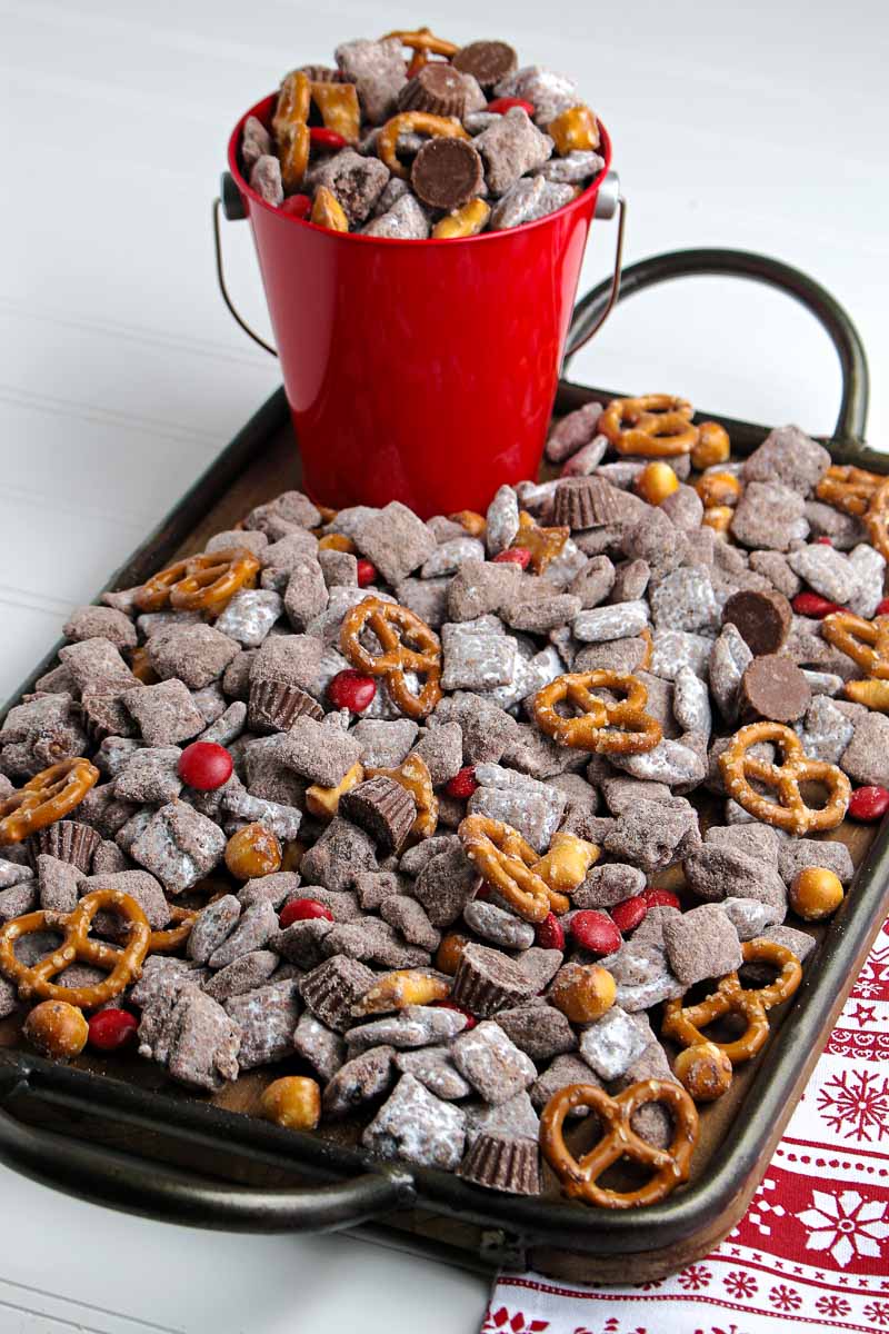 A tray of chocolate pretzels and pretzels on top of a red bucket.