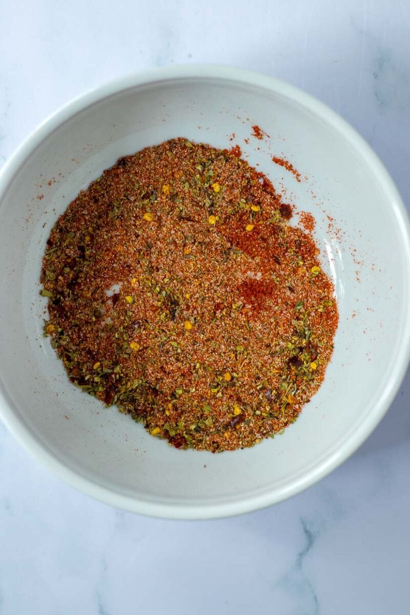 A white bowl with a mixture of spices in it.
