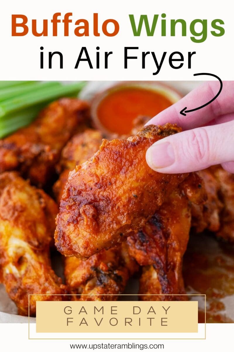 A hand holds a cooked wing above a plate of air fryer buffalo wings, with "Buffalo Wings in Air Fryer" and "Game Day Favorite" text on the image.