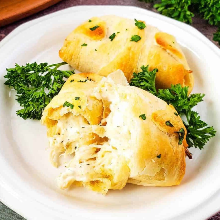 Chicken crescent rolls on a plate with parsley.