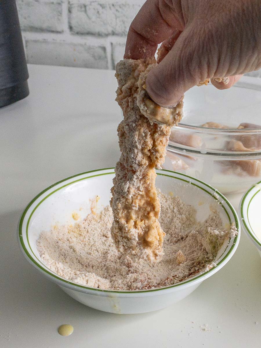 A person putting flour into a bowl.
